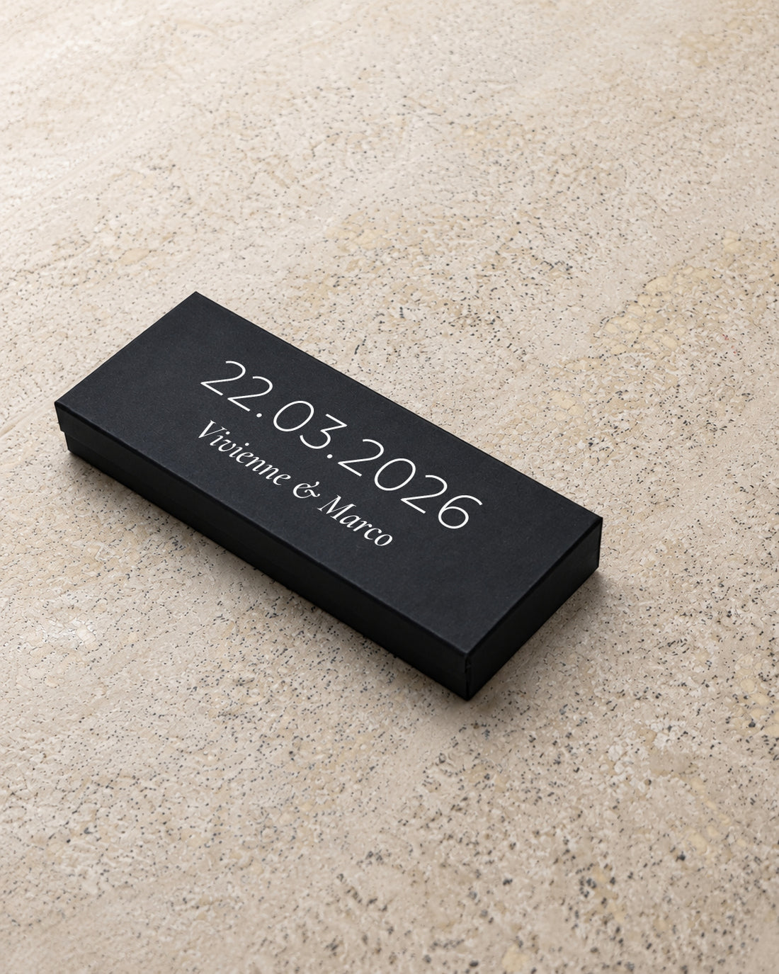 Beacon slim matchbox in black, closed at an angle on stone