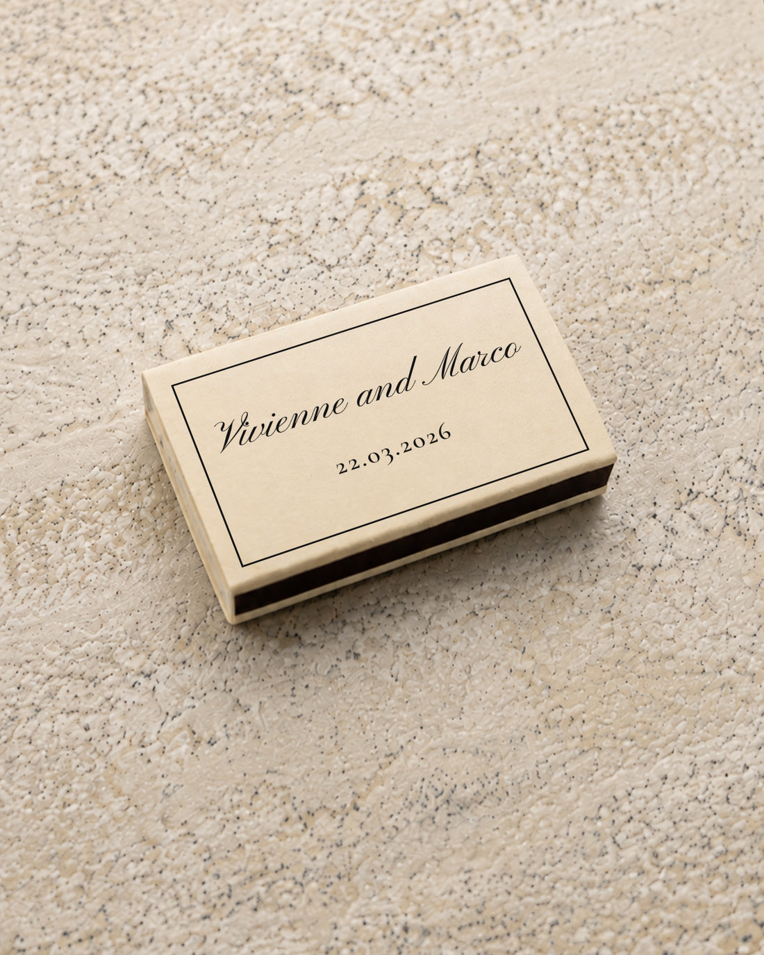 Vivienne classic matchbox in ivory, closed at an angle on stone