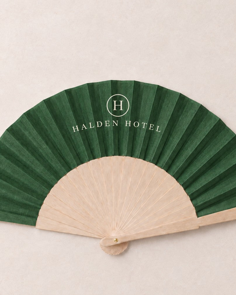 Closer view of the green printed leaf and plain bamboo ribs of a branded fan