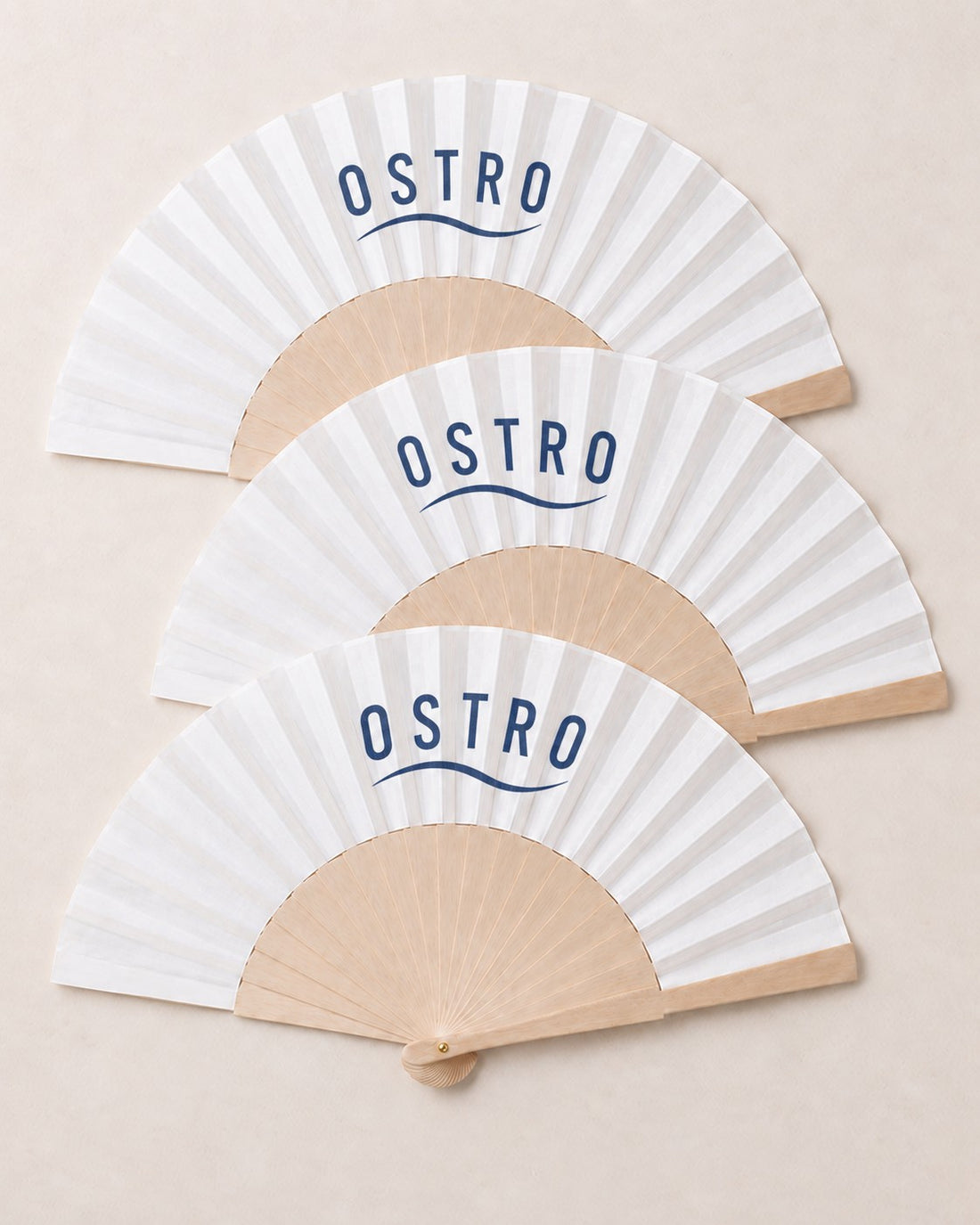 Three branded fans with a navy wordmark on white leaves, an example brand