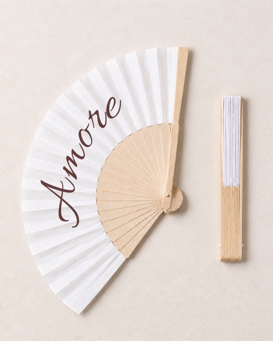 Amore, open and closed, solid bamboo fan on light marble