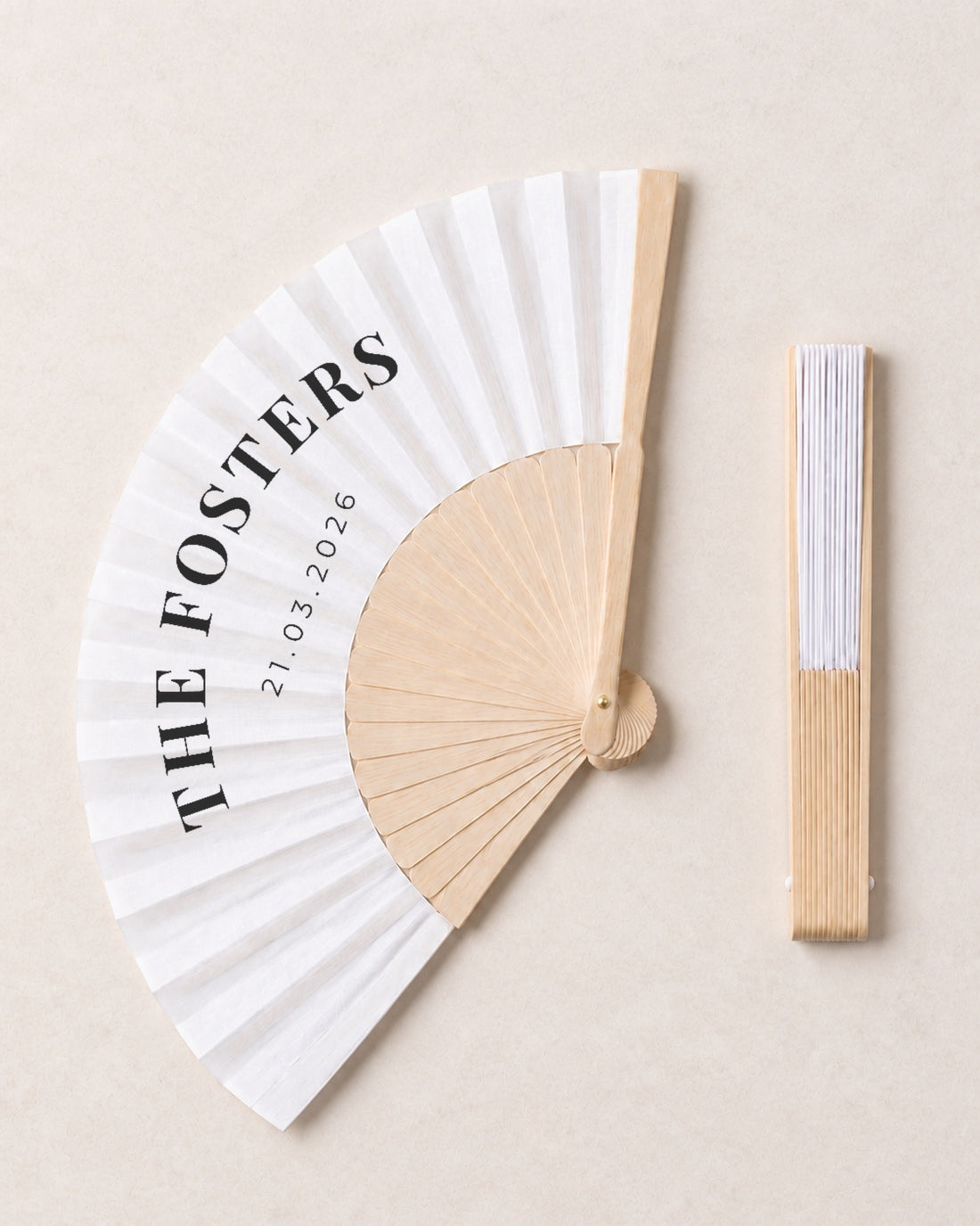 The Name, open and closed, solid bamboo fan on light marble