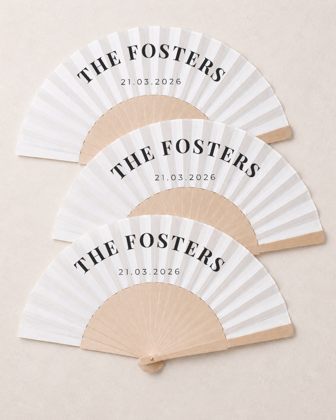 The Name, three open fans, solid bamboo fan on light marble