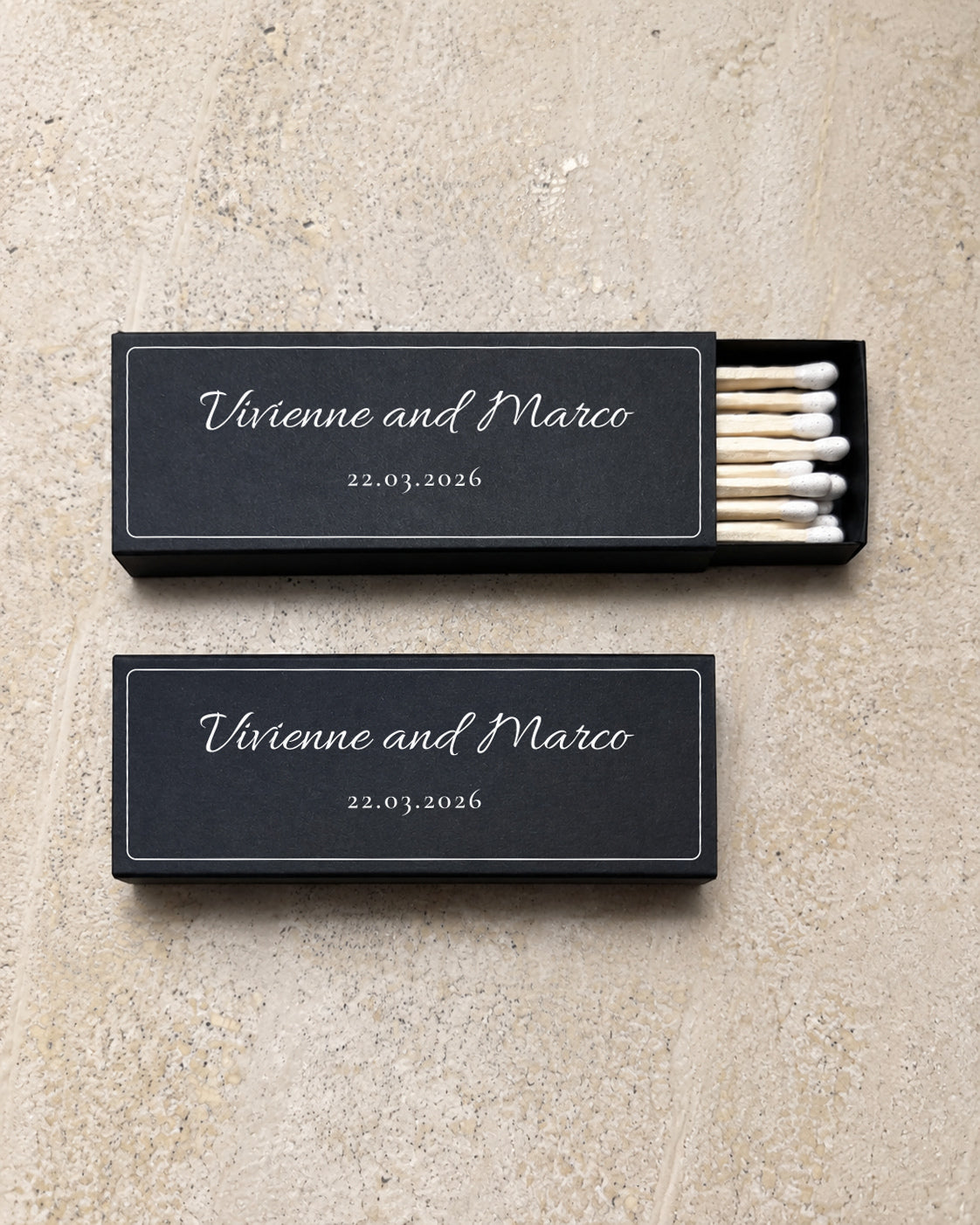 Flint slim matchbox in black, open and closed pair on stone