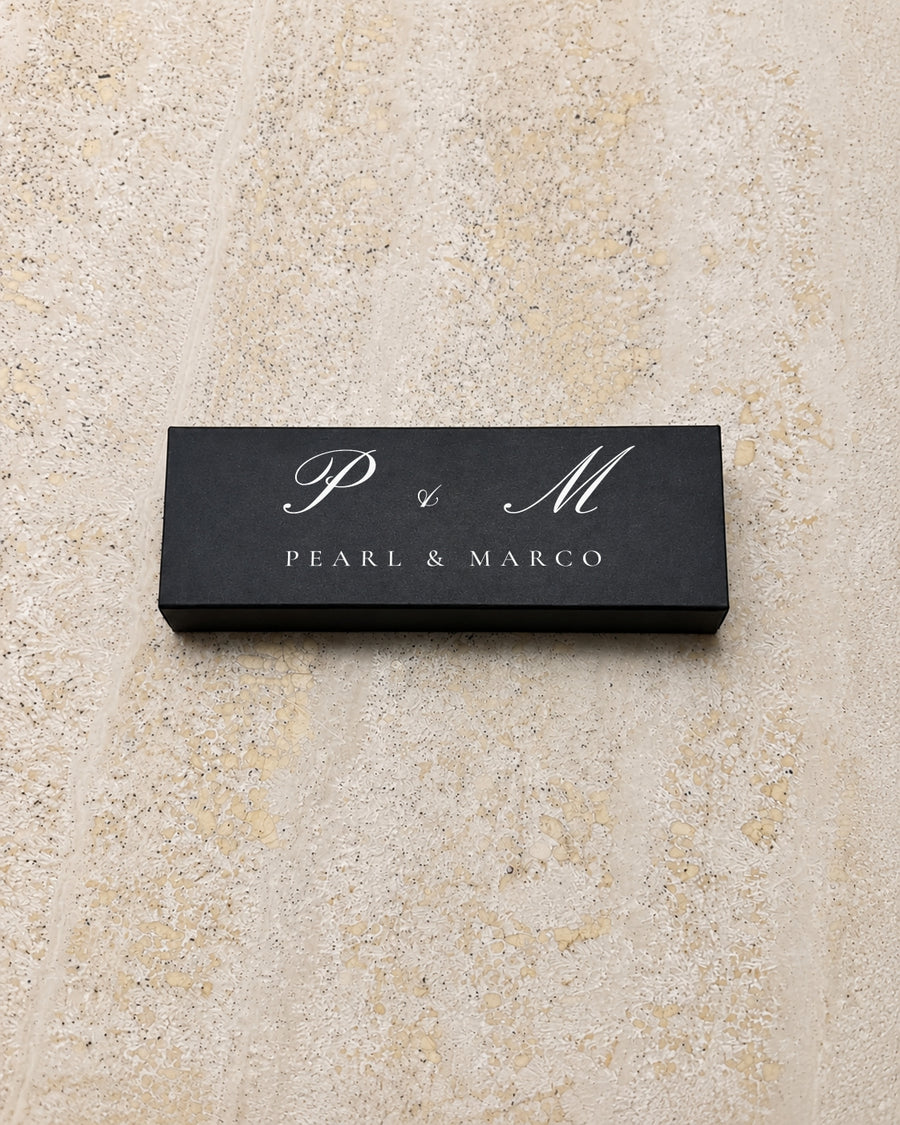 Pearl slim matchbox in black, closed on stone