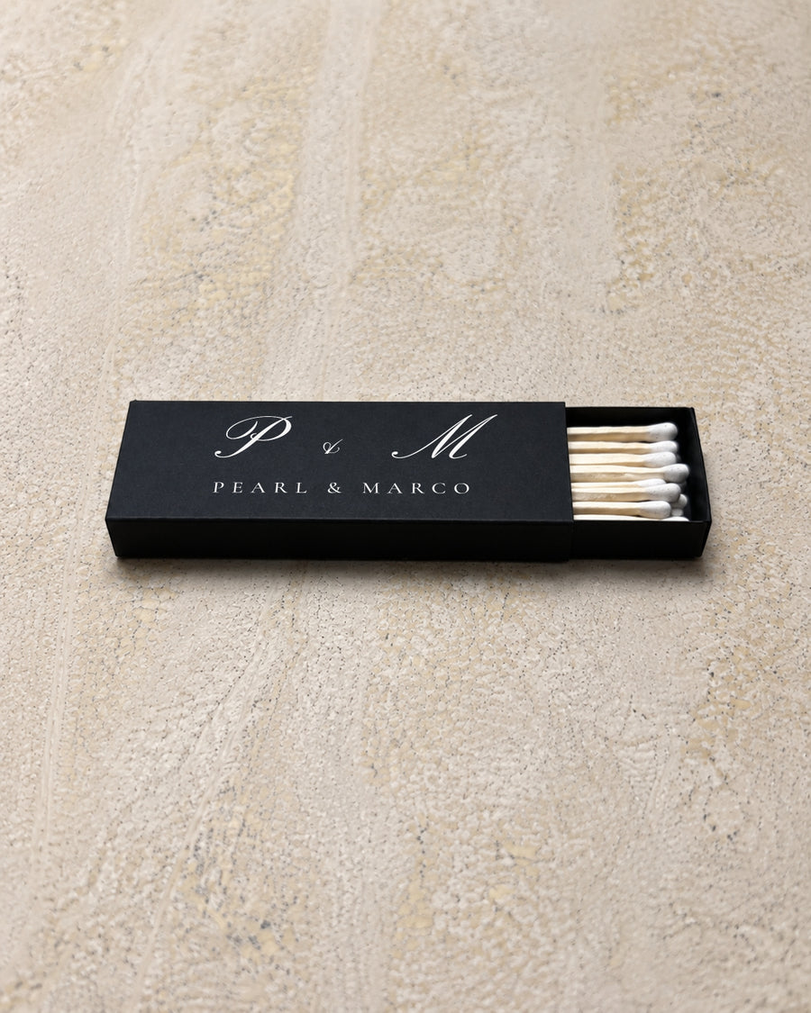 Pearl slim matchbox in black, partly open on stone
