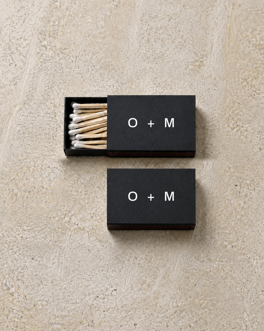 Emblem classic matchbox in black, open and closed pair on stone