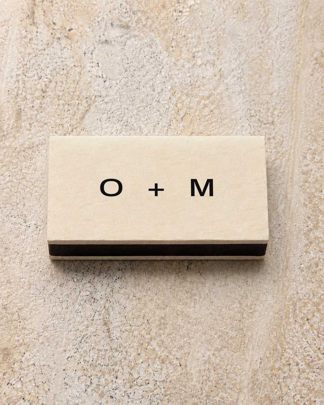 Emblem classic matchbox in ivory, closed on stone