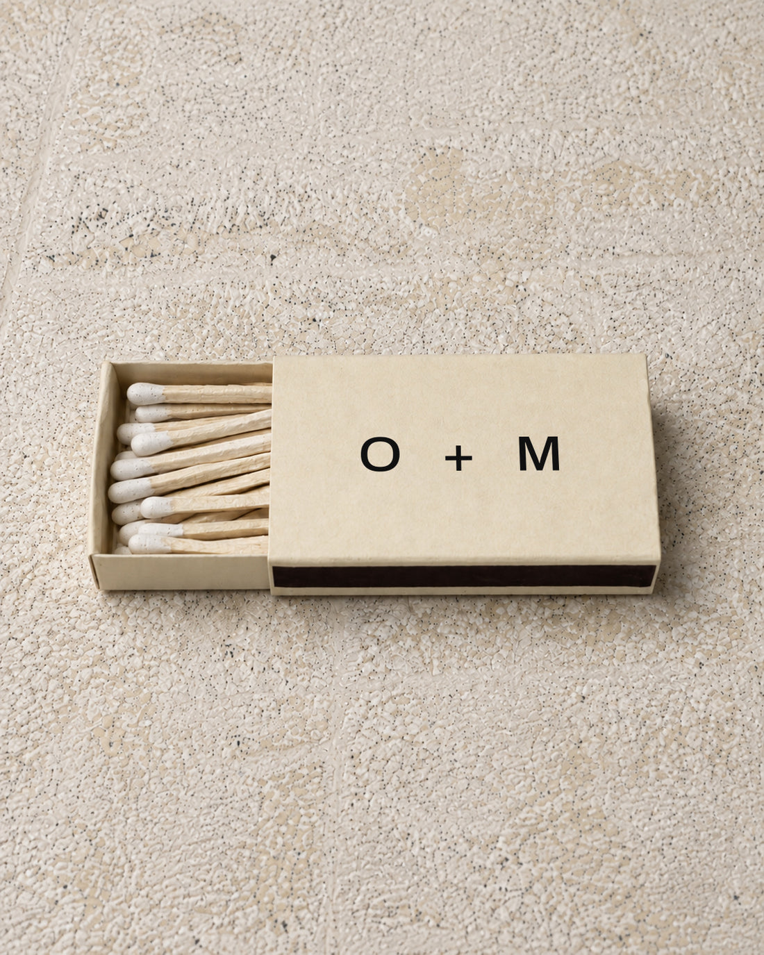 Emblem classic matchbox in ivory, partly open on stone