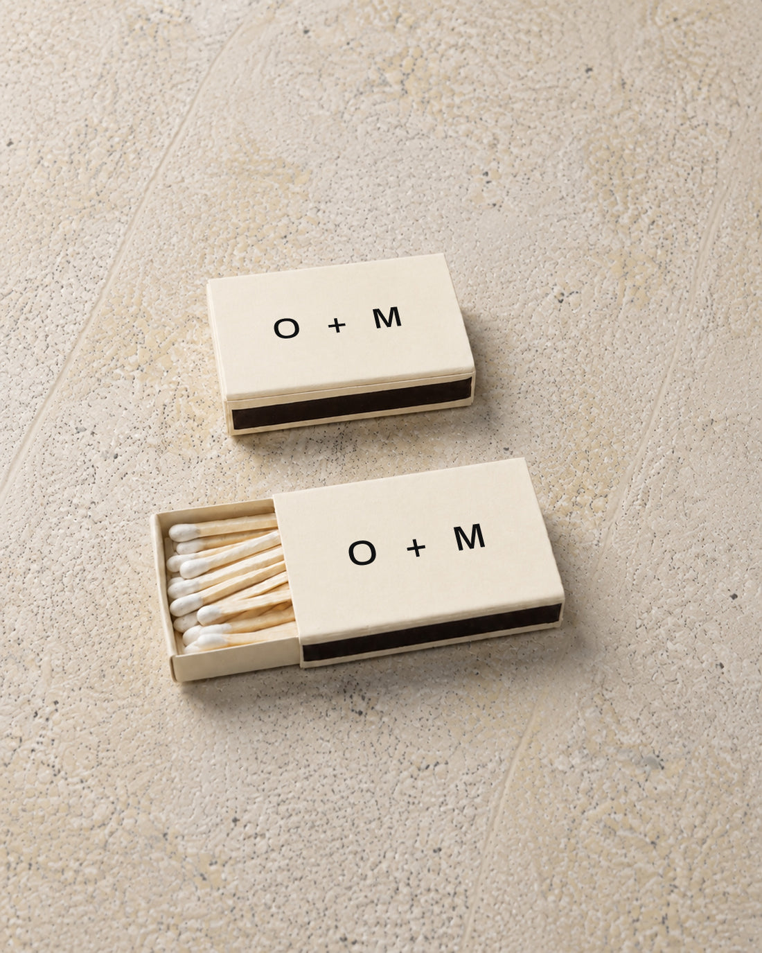 Emblem classic matchbox in ivory, angled open and closed pair on stone