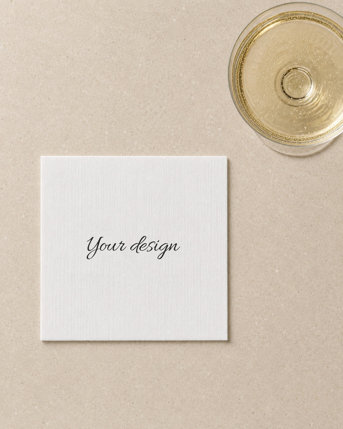 A blank cocktail napkin printed with the words Your design, styled with a coupe