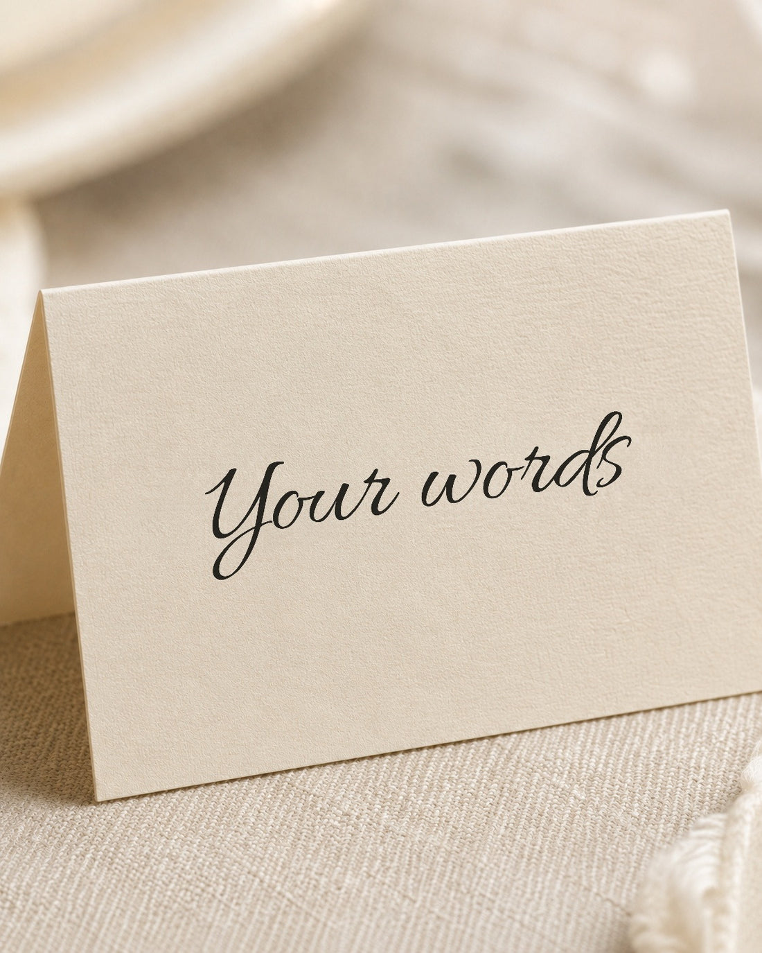 A blank wedding place card printed with the words Your words, angled close