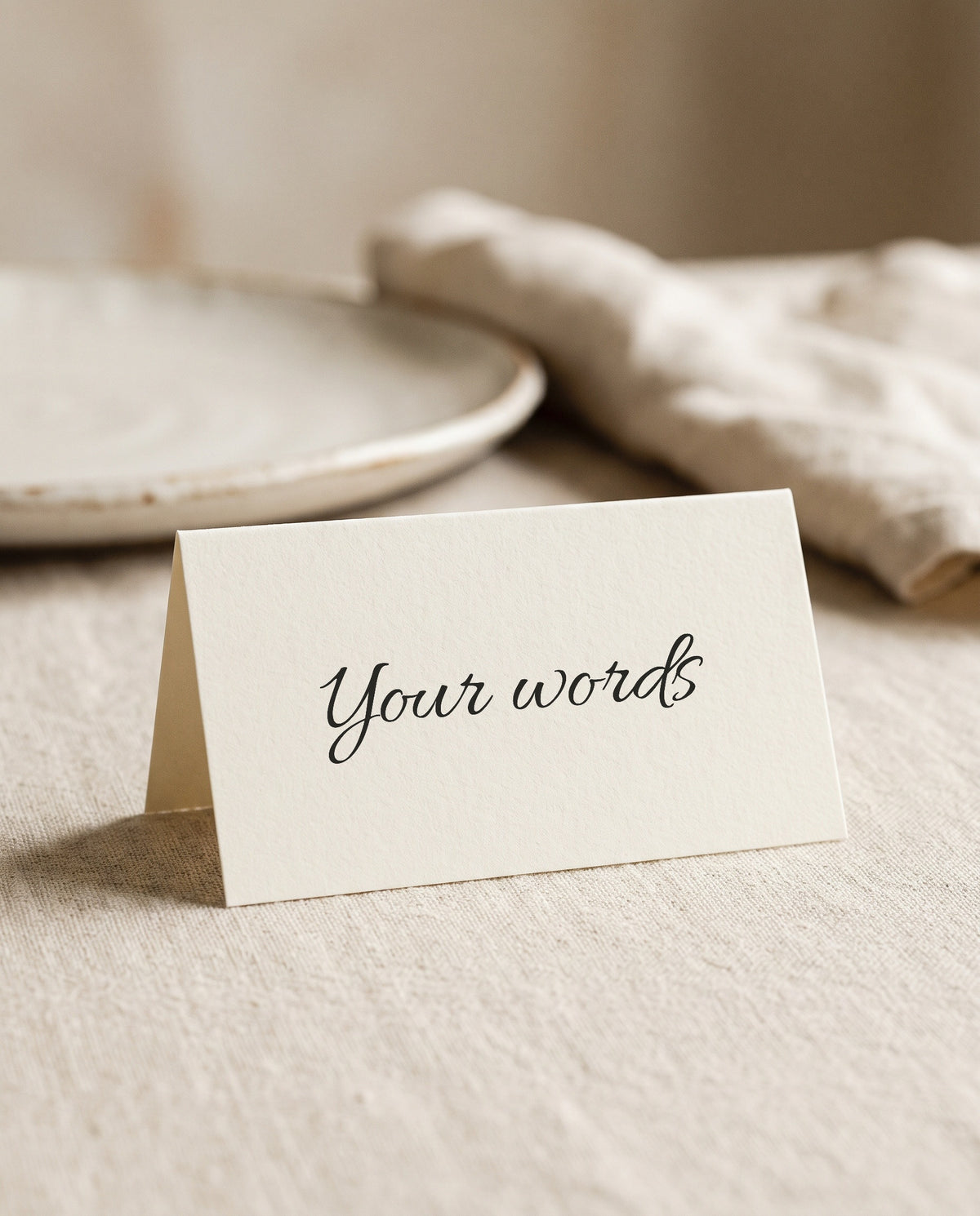 A blank wedding place card printed with the words Your words, at a place setting