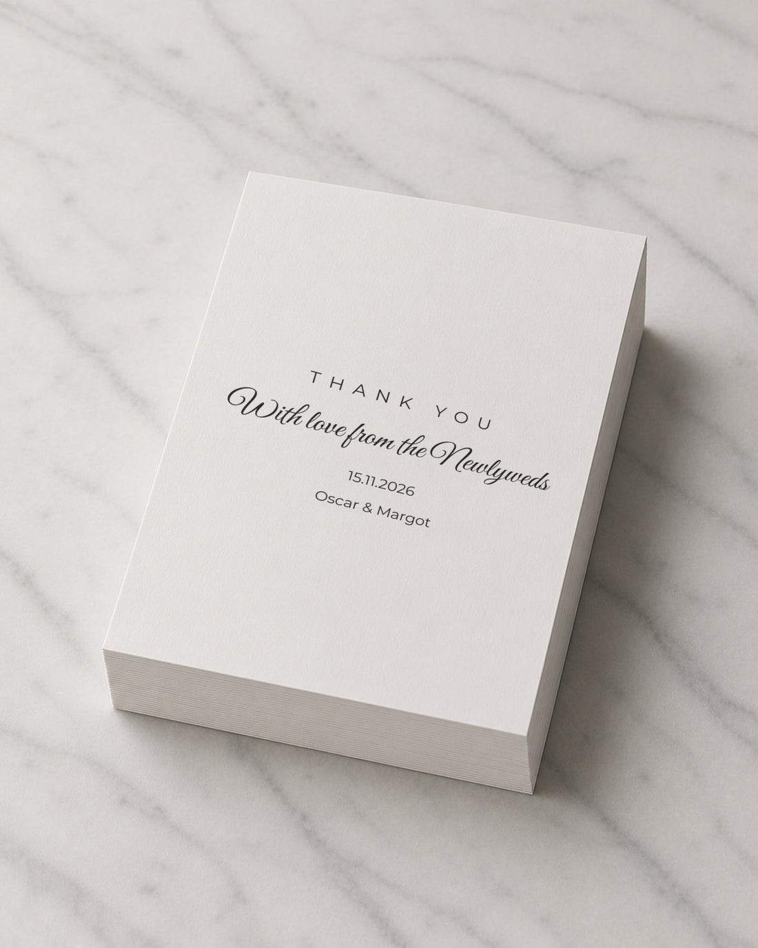 A thick stack of Newlyweds thank you cards on marble