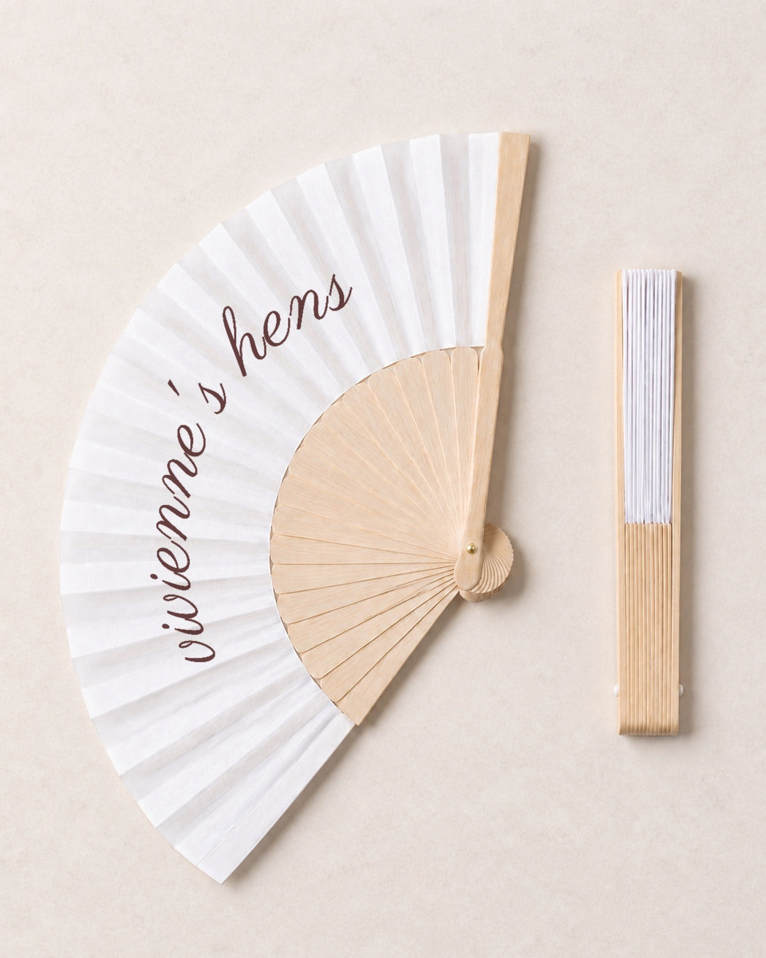 The Hen, open and closed, solid bamboo fan on light marble