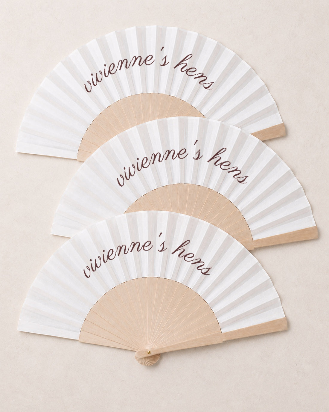 The Hen, three open fans, solid bamboo fan on light marble