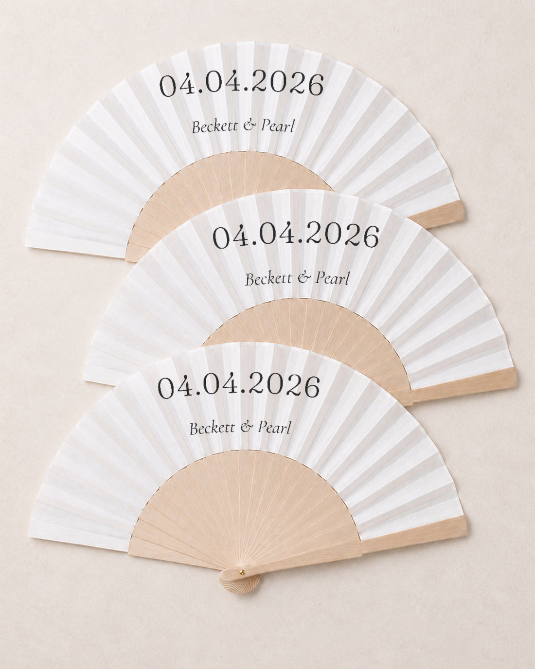 The Date, three open fans, solid bamboo fan on light marble