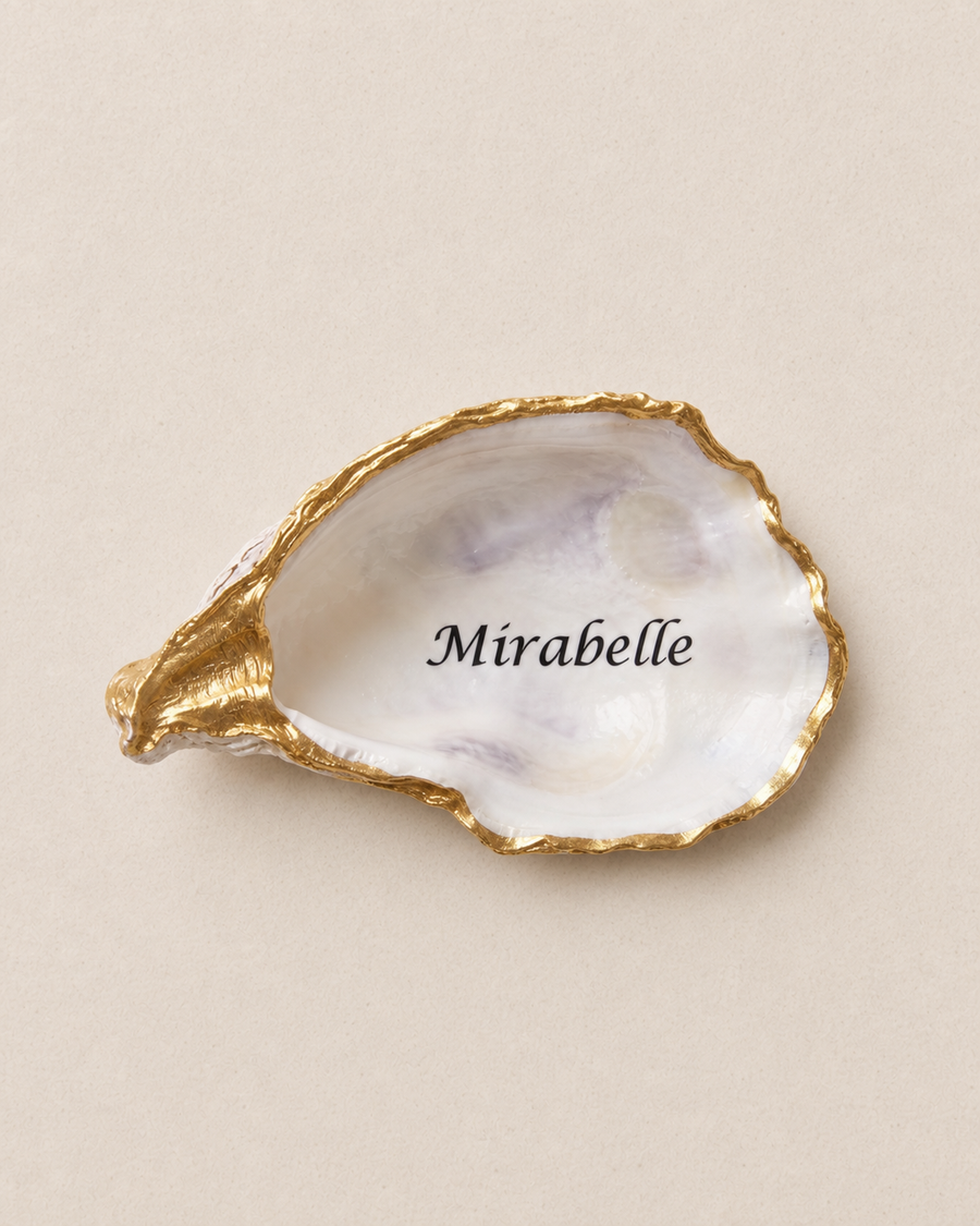 Gold trim oyster shell place cards, personalised with each guest's name